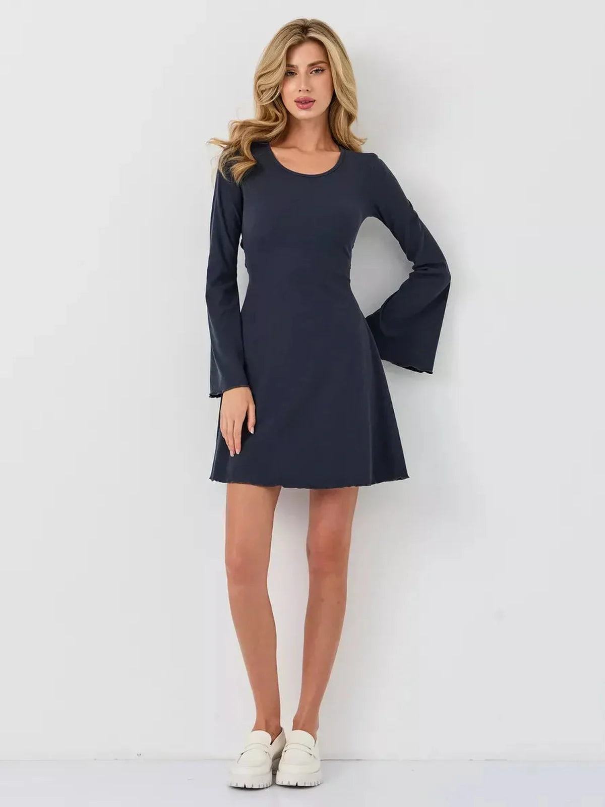Confident woman in a navy mini dress with bell sleeves, perfect for summer, cocktail, or casual occasions.