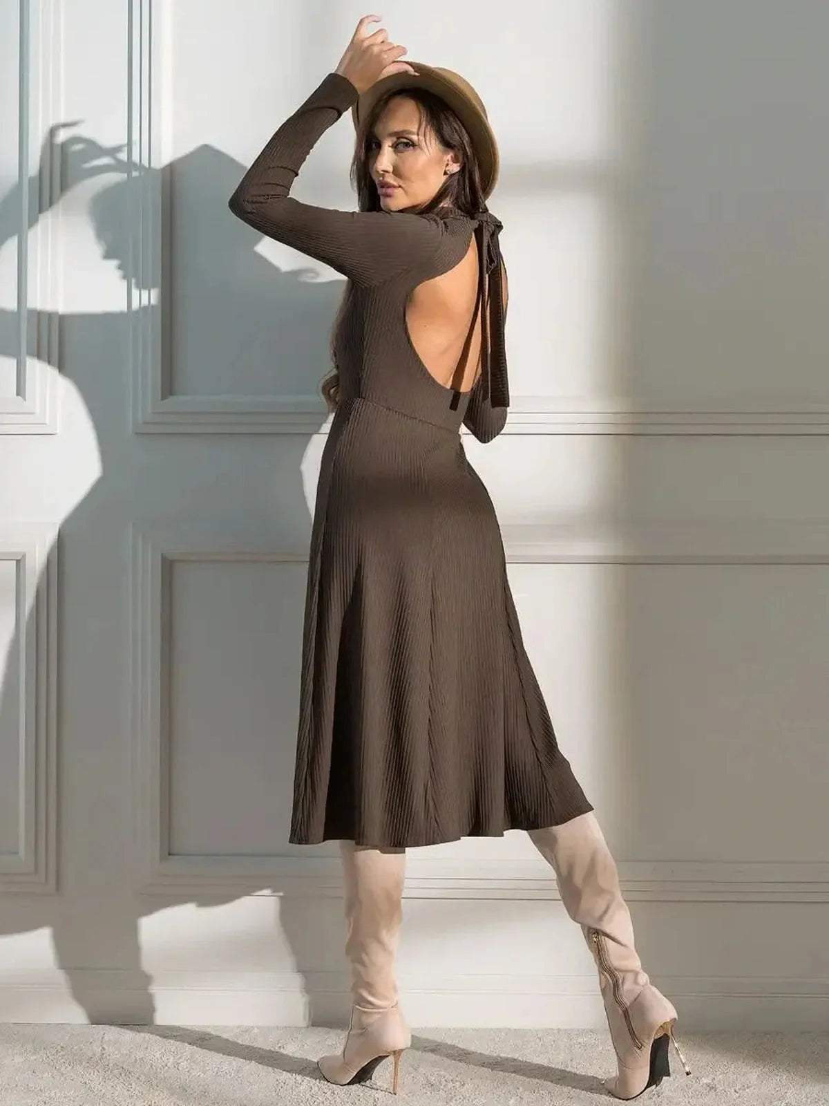 Model showcasing the Mocha Muse Midi Dress with open back and soft ribbed texture, styled with knee-high boots.