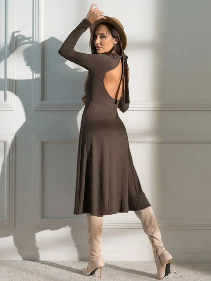 Model showcasing the Mocha Muse Midi Dress with open back and soft ribbed texture, styled with knee-high boots.