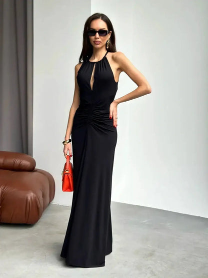 Elegant black maxi dress featuring a ruched halter neckline and alluring front slit, perfect for weddings and formal events.