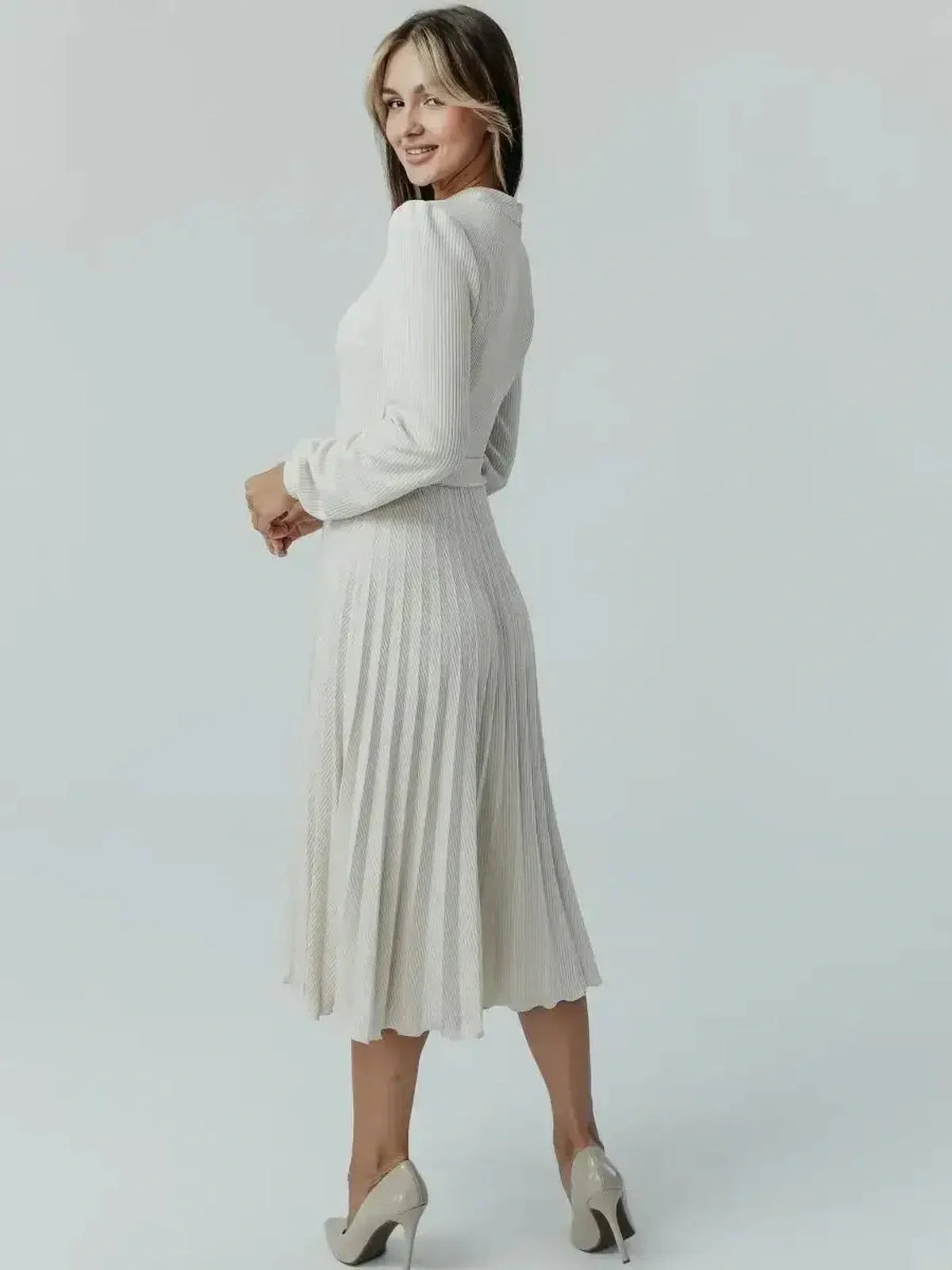 Back view of a woman wearing the Grace Pleat Midi Dress in cream, highlighting its pleated skirt and fitted bodice.