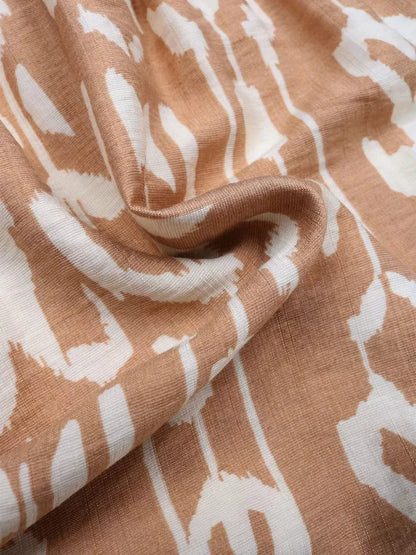 Close-up of lightweight fabric with a bohemian geometric print in soft brown and cream tones, ideal for dresses.