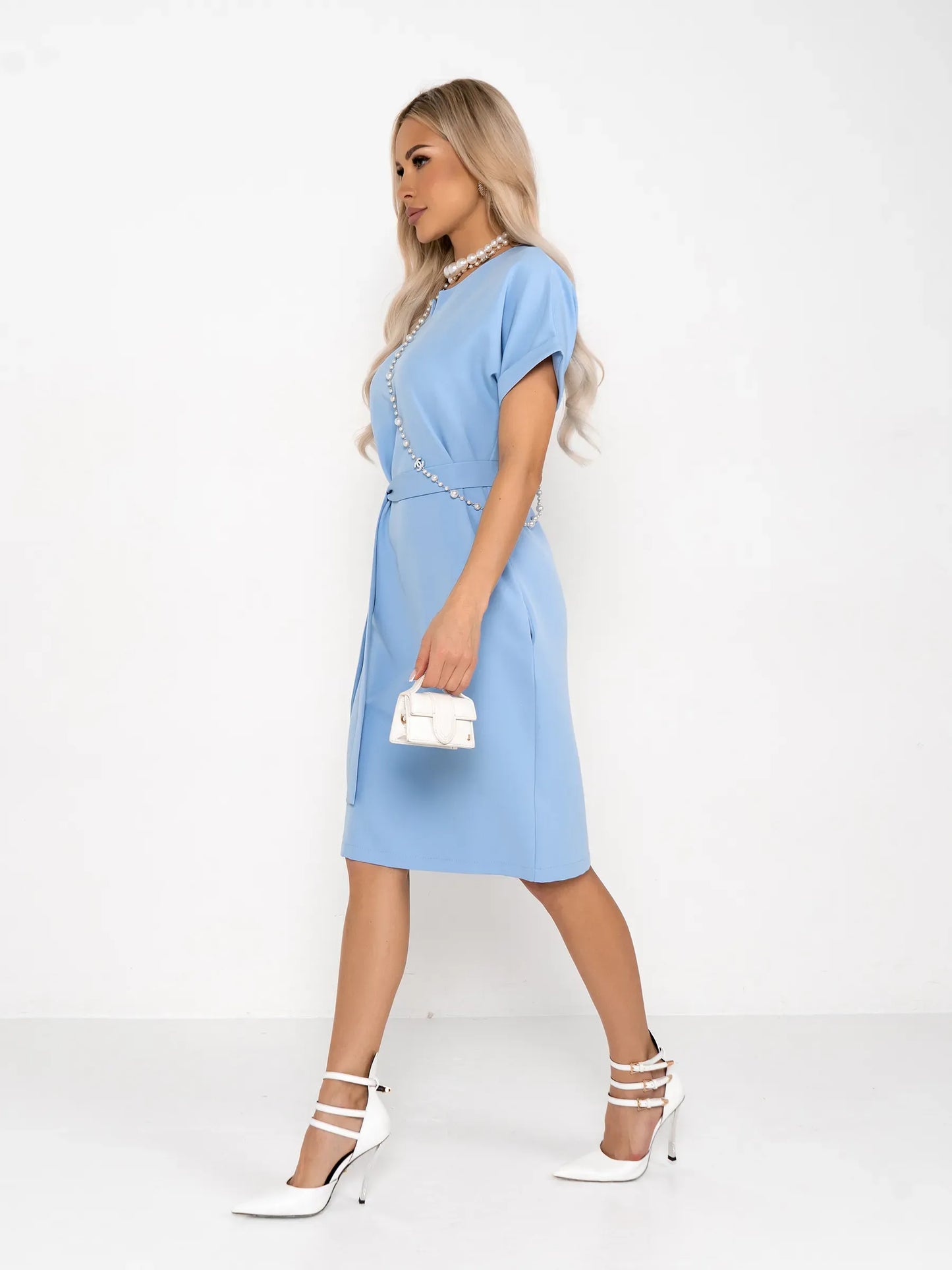 A model wearing a light blue mini dress with rolled sleeves and a self-tie belt, perfect for weddings or casual events.