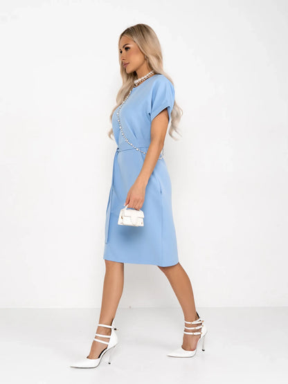 A model wearing a light blue mini dress with rolled sleeves and a self-tie belt, perfect for weddings or casual events.