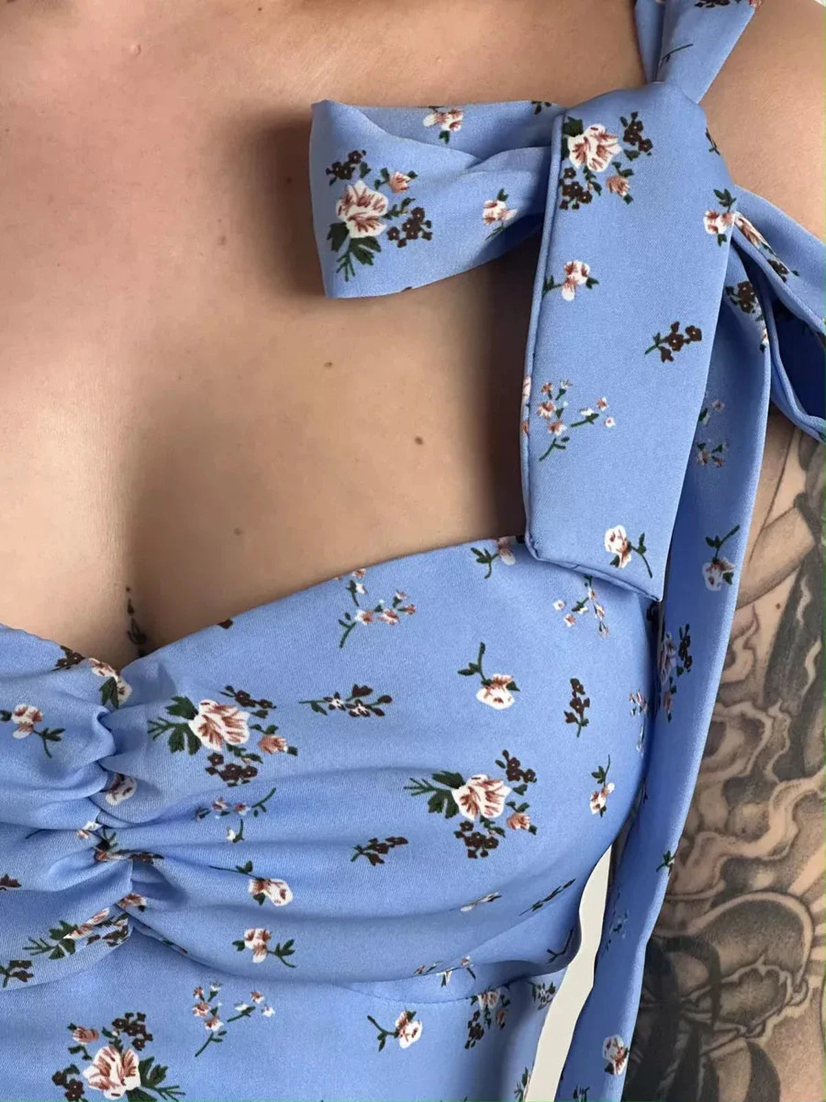 Close-up of Floral Charm Midi Dress featuring blue floral print and elegant shoulder ties, perfect for summer weddings.