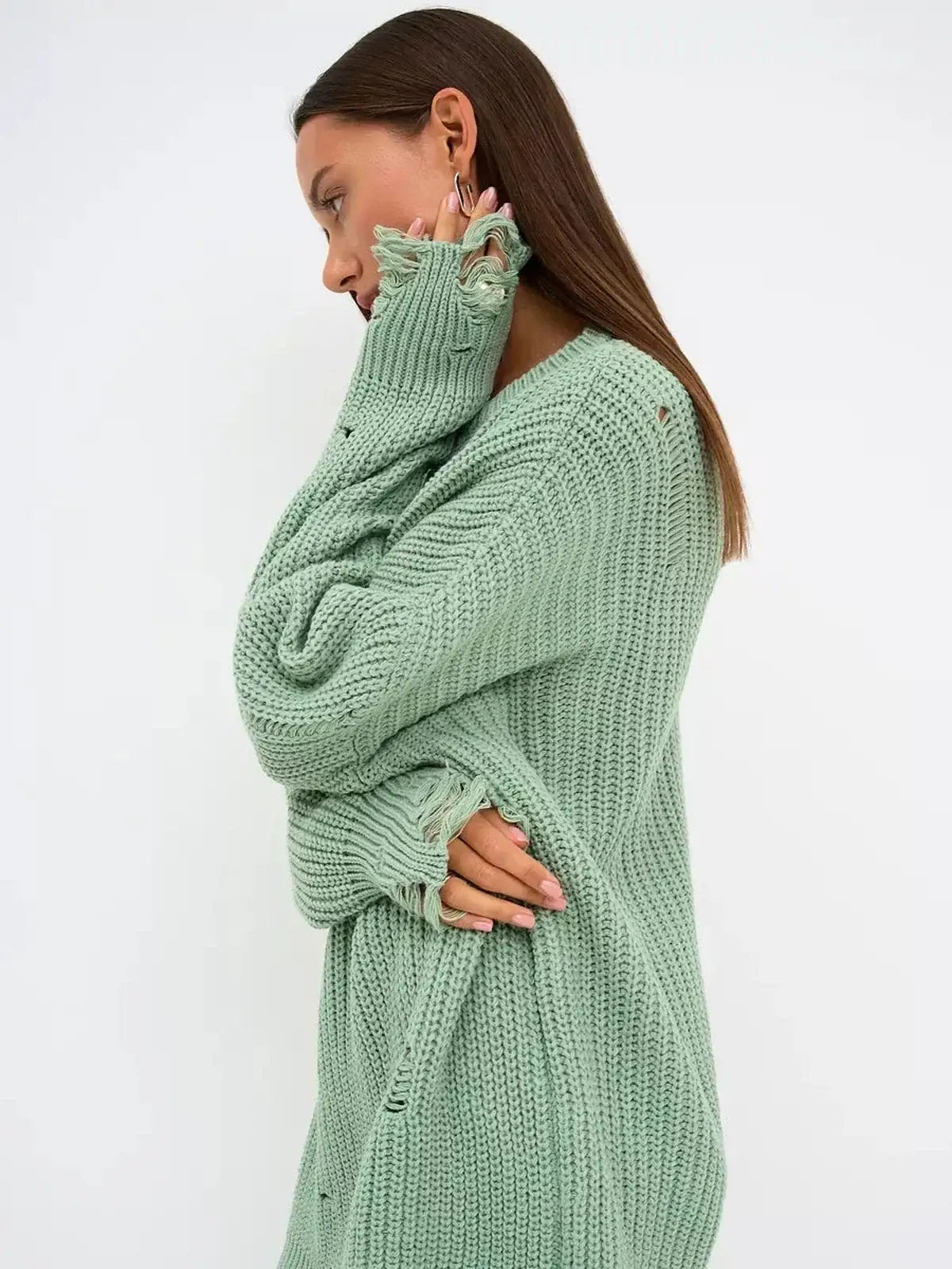 Model wearing a soft mint green Frost Knit Mini sweater dress with distressed accents, showcasing oversized fit and chunky knit texture.