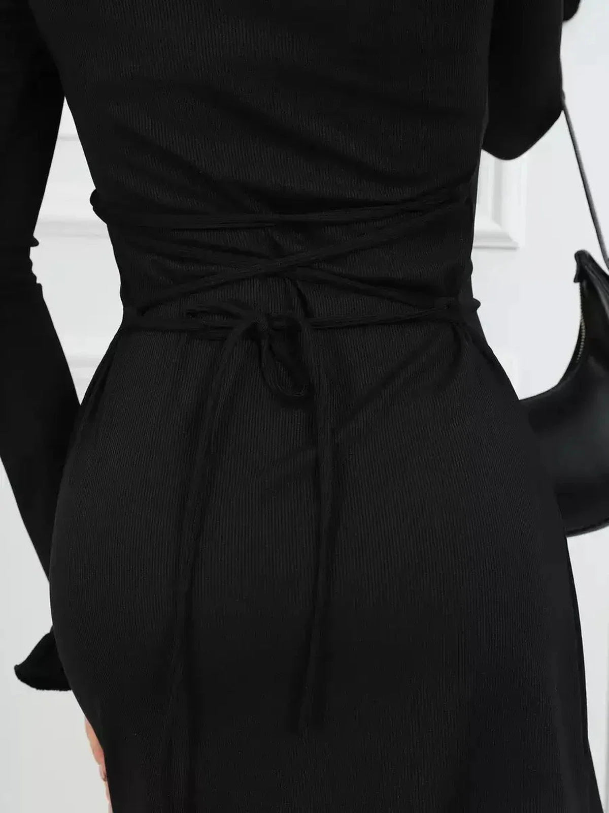 Detail of a black Velvet Lace Mini dress showcasing the corset-inspired lace-up back design, perfect for stylish evening wear.