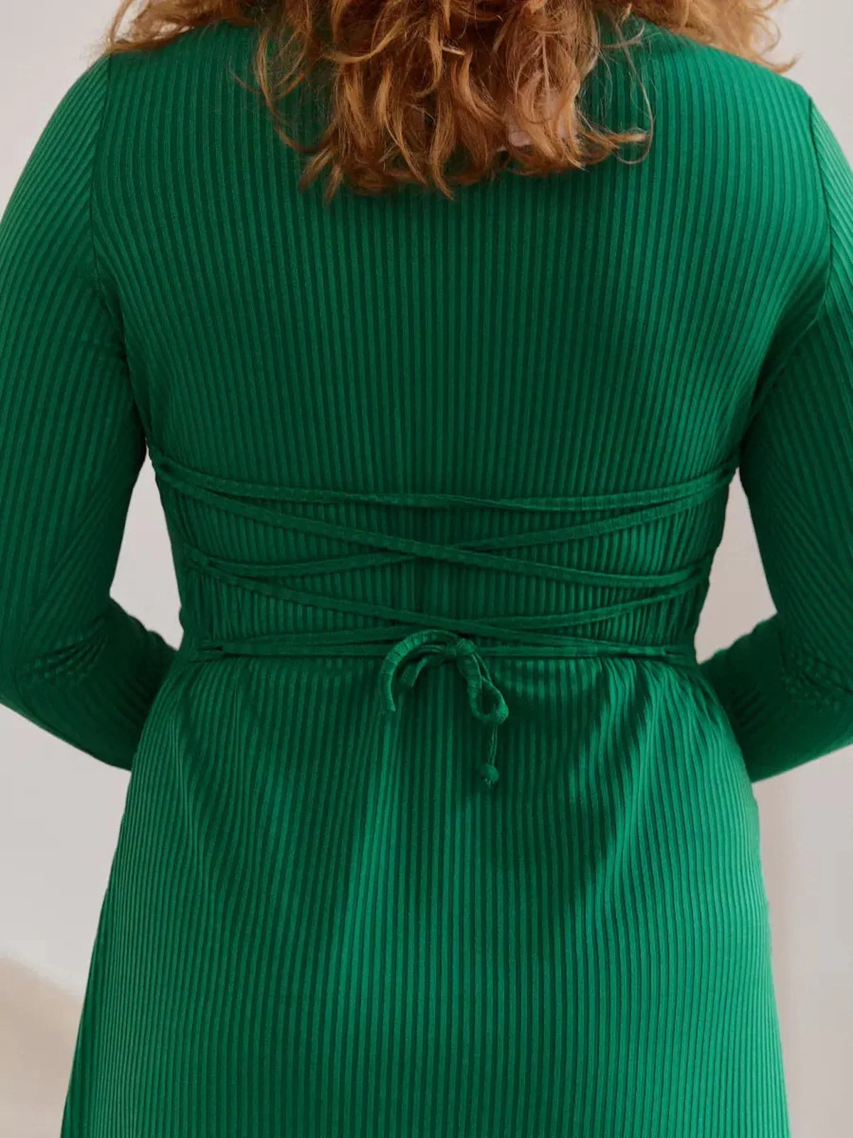 Back view of the Luxe Sculpt Midi Dress showcasing elegant waist tie detailing and ribbed texture in vibrant green.