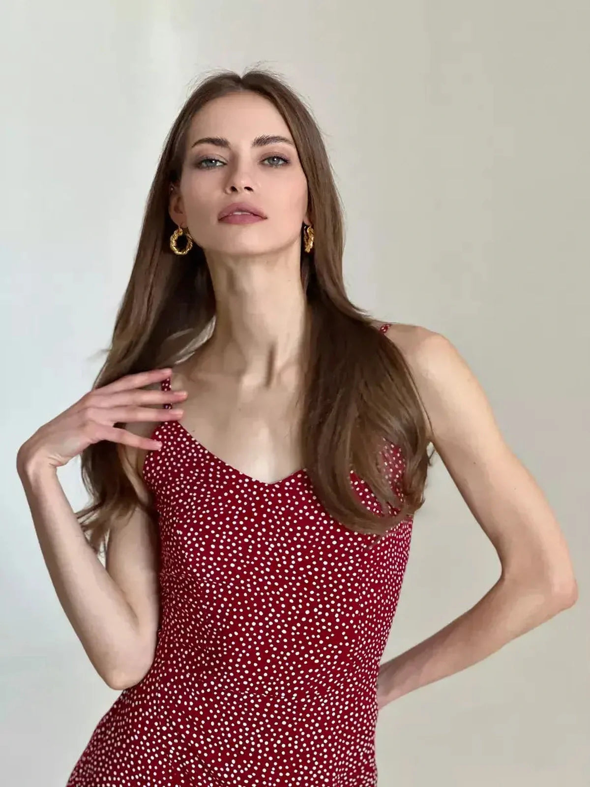 Model showcasing the Cherry Dots Midi Dress in red with white polka dots, perfect for summer events and special occasions.
