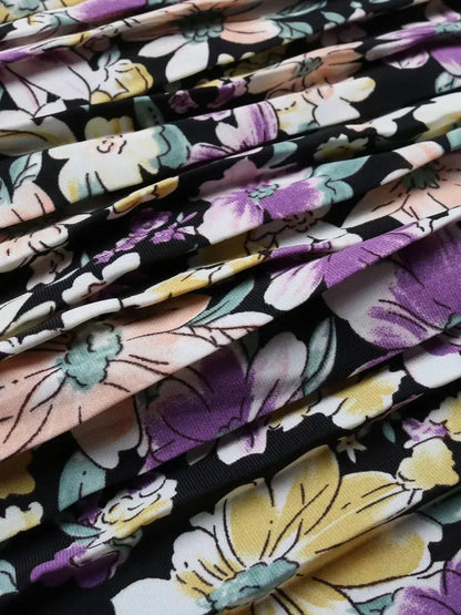 Close-up of floral fabric featuring colorful blooms on a black background, perfect for elegant summer dresses.