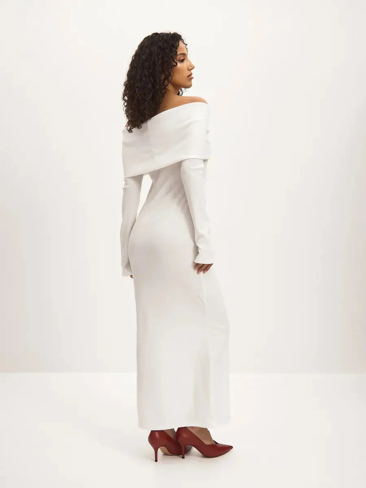 Model showcasing the Sculpted Grace Maxi Dress, an elegant off-shoulder white dress with a sleek silhouette.