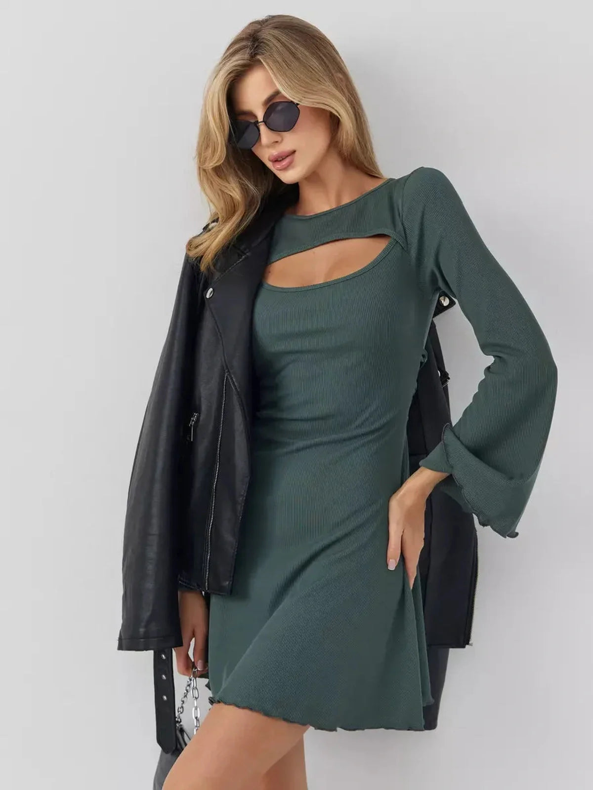 Dark olive mini dress with a cut-out neckline, bell sleeves, and a stylish leather jacket for a chic look.