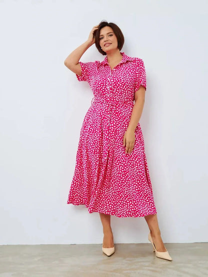 Model wearing the vibrant Petal Pop Midi Dress in fuchsia with abstract white petals, ideal for summer events and casual occasions.