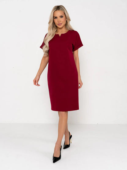 Model wearing a bold wine-red Crimson Code mini dress with structured silhouette and notched neckline.