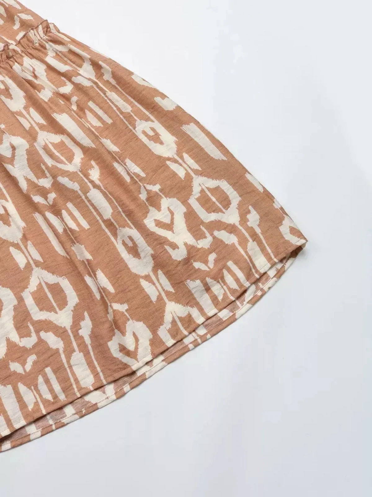 Close-up of the Nomad Tiered Midi Dress featuring a bohemian geometric print in soft brown tones, perfect for summer days.