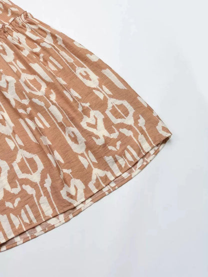 Close-up of the Nomad Tiered Midi Dress featuring a bohemian geometric print in soft brown tones, perfect for summer days.