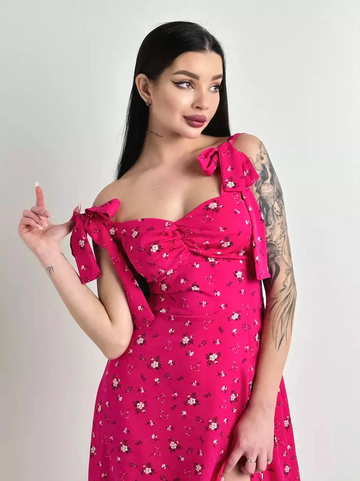 Model showcases the Rosé Charm Midi Dress with floral print and adjustable ties, perfect for summer events and weddings.