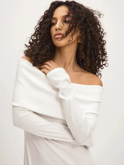 Model wearing the Sculpted Grace Maxi Dress, featuring an off-shoulder design in soft white fabric.