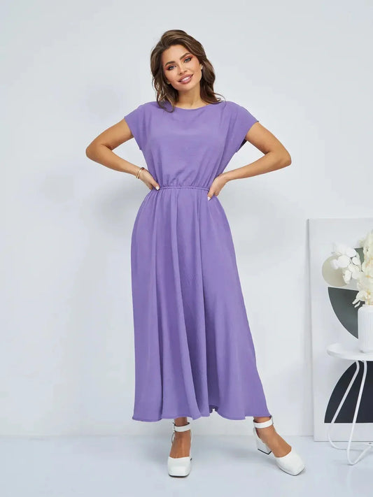 Woman in a light lavender maxi dress with a gathered waist, perfect for summer gatherings and wedding guest events.