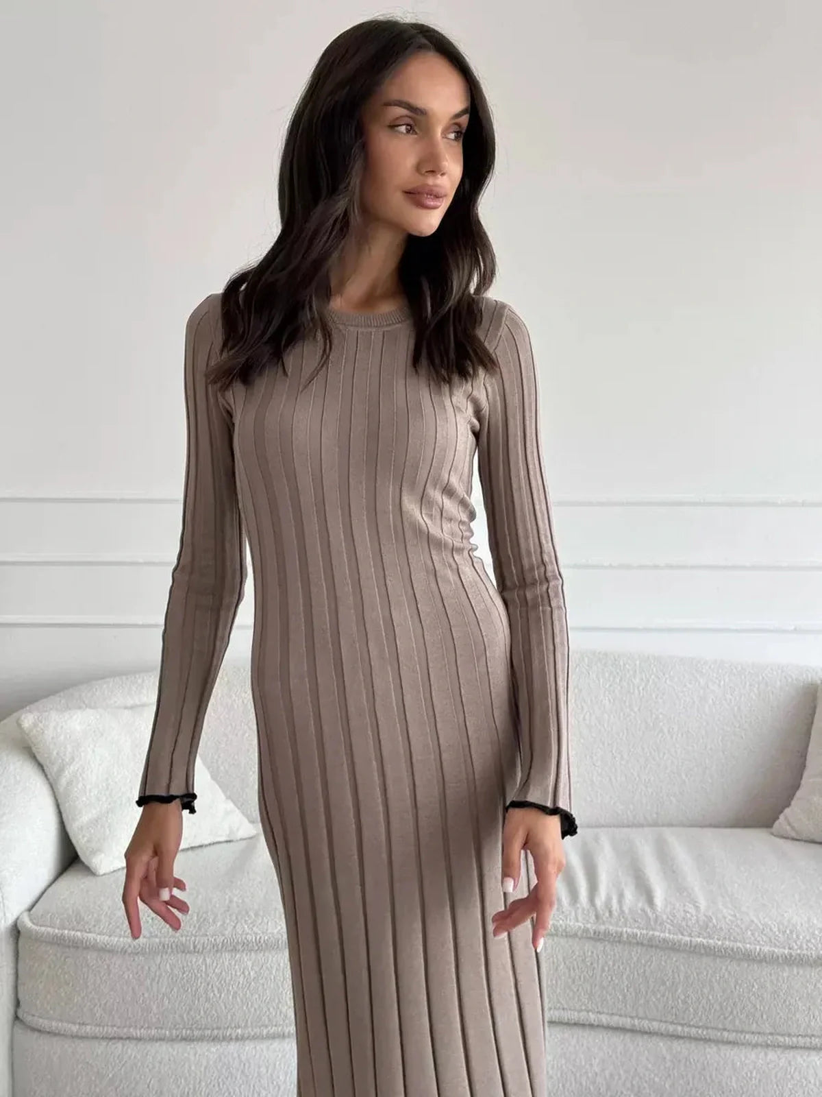 Model showcasing the Contour Maxi Dress in ribbed knit, highlighting its elegant silhouette and long sleeves.