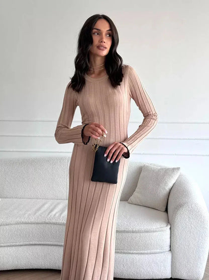 Model wearing the Sahara Curve Maxi Dress in Sandstone Beige, showcasing its elegant ribbed design and figure-hugging silhouette.