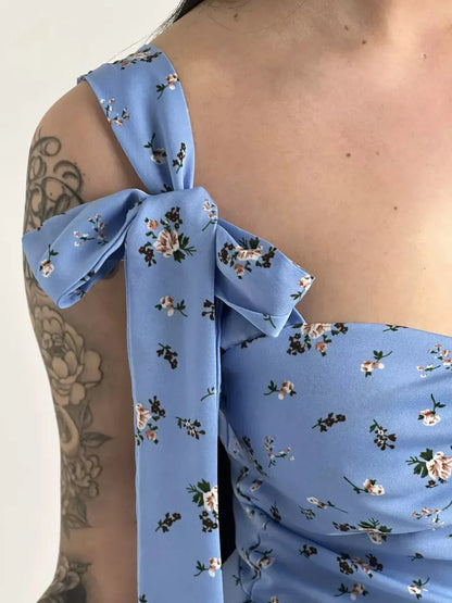 Close-up of the floral charm midi dress featuring a blue floral print and elegant shoulder bow tie detail.