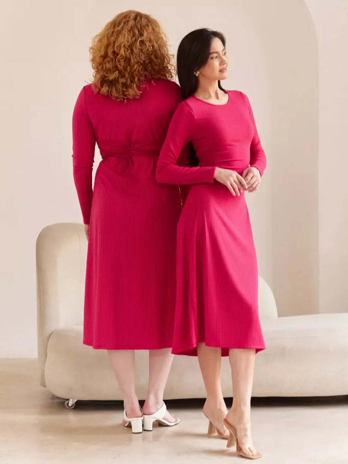 Two women in a pink contour midi dress featuring waist-tie detailing, showcasing stylish summer and wedding guest attire.