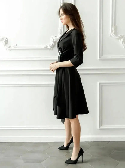 Midnight Fold Midi Dress in black, featuring a wrap bodice, asymmetric hem, and cinched waist with silver-tone ring.