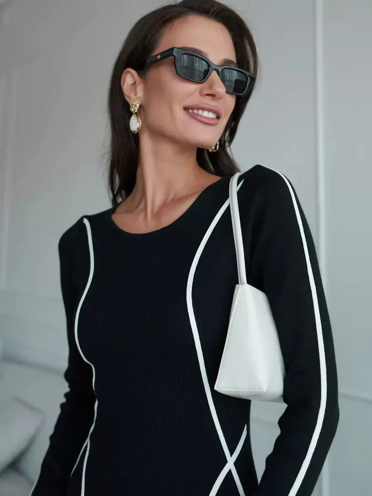 Model wearing the Midnight Curve Maxi Dress with elegant lines and contrast piping, showcasing a sophisticated look.