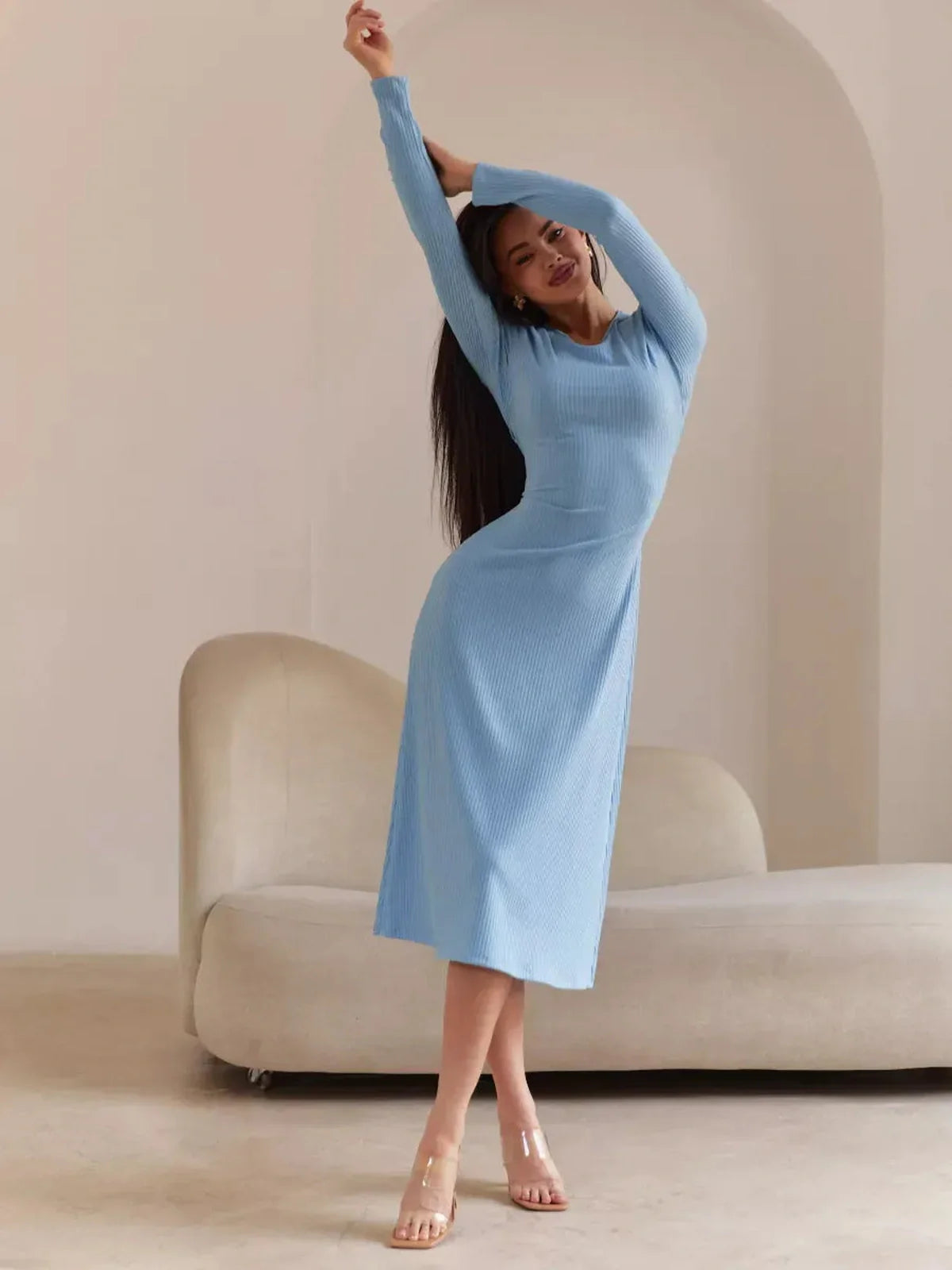 Model showcasing a Sculpted Grace Midi Dress in light blue, featuring long sleeves and a flattering silhouette.