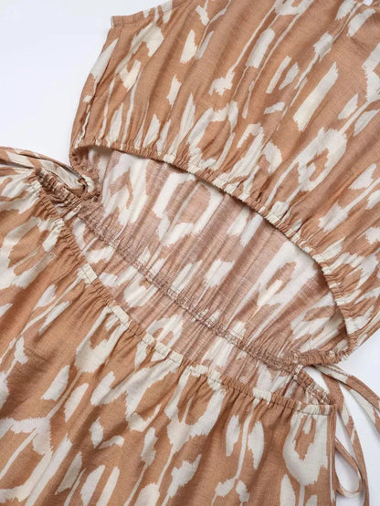 Close-up of the Nomad Tiered Midi Dress showcasing its tiered design and bohemian geometric print in soft beige tones.