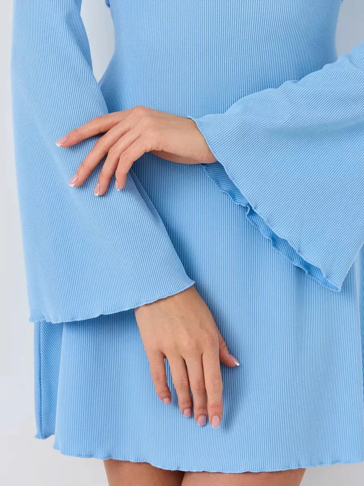 Close-up of flared sleeves and hands in a light blue Skyline Flare mini dress, perfect for summer and wedding guest occasions.