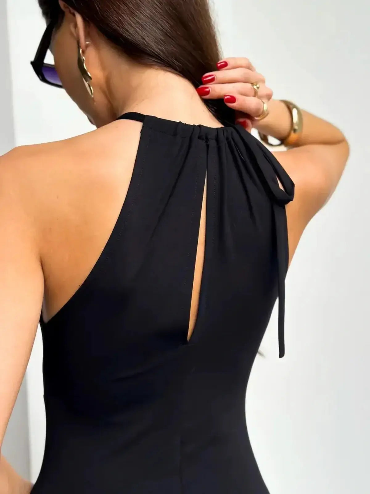 Back view of the Maxi Dress Obsidian showcasing the ruched halter design and elegant keyhole detail.