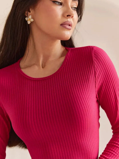 Close-up of a model wearing a pink ribbed dress showcasing elegant neckline and earrings, ideal for summer and casual occasions.