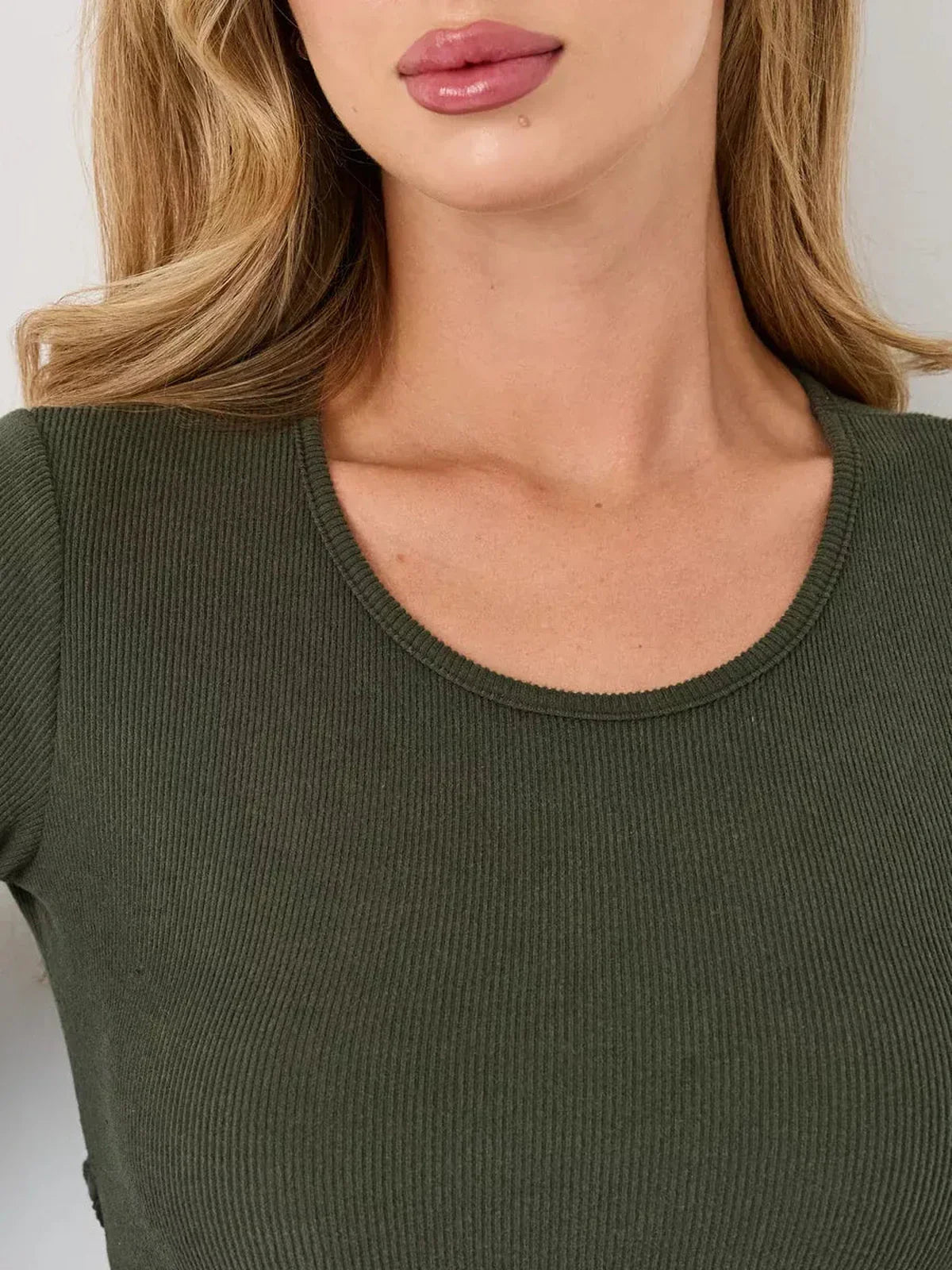 Close-up of a woman's neckline in a ribbed, olive green mini dress, showcasing comfort and style for summer dresses.