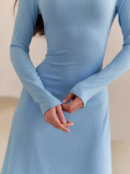 Elegant blue midi dress with ribbed texture, featuring long sleeves and a flattering silhouette.