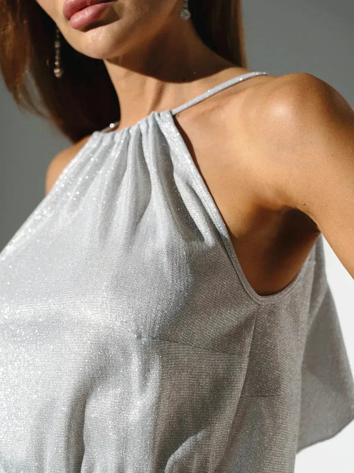 Close-up of the shimmer fabric and straps of a Celestial Glow Midi Dress, showcasing its elegant design and backless style.