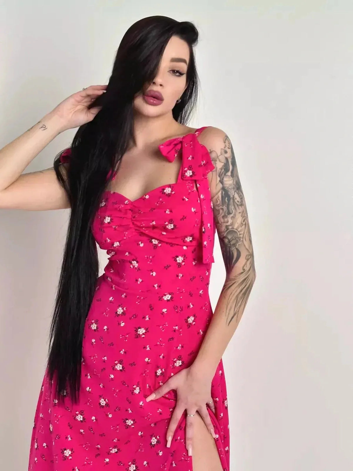 Model wearing the Rosé Charm Midi Dress, featuring a pink floral print and sweetheart tie detail, perfect for summer events.