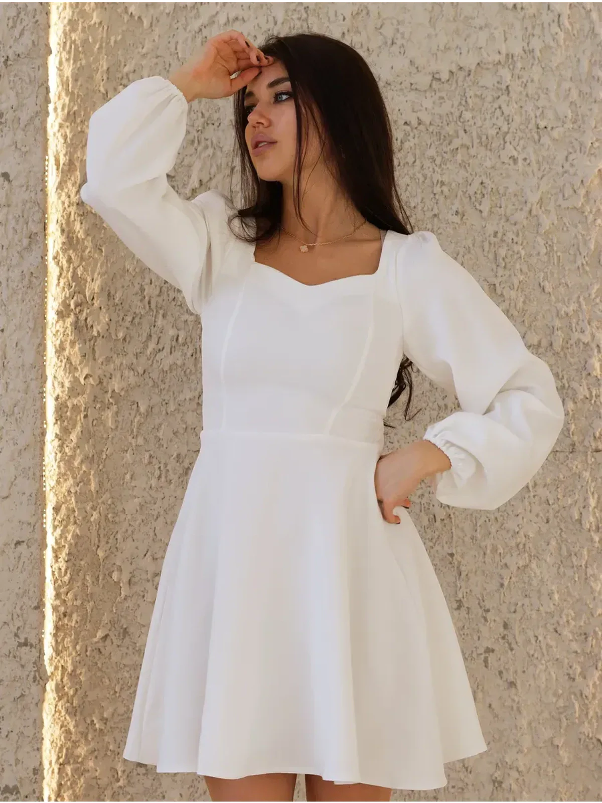 Stylish woman in a white structured dress with a sweetheart neckline, perfect for summer, weddings, or graduation events.