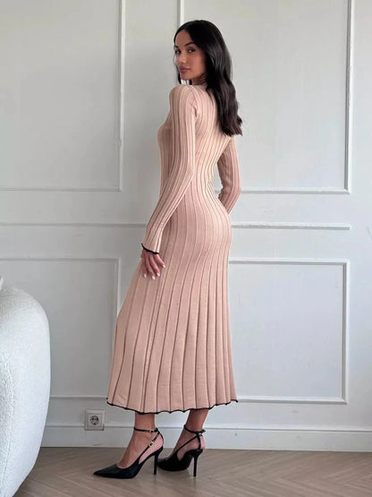 Model showcasing the Sahara Curve Maxi Dress in sandstone beige, featuring a ribbed texture and elegant full-length cut.