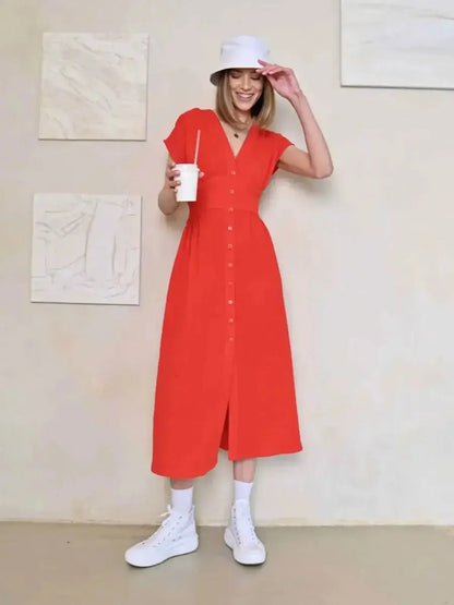 Confident woman in a Flare Muse Midi Dress, featuring a V-neck and buttons, styled with sporty white sneakers.