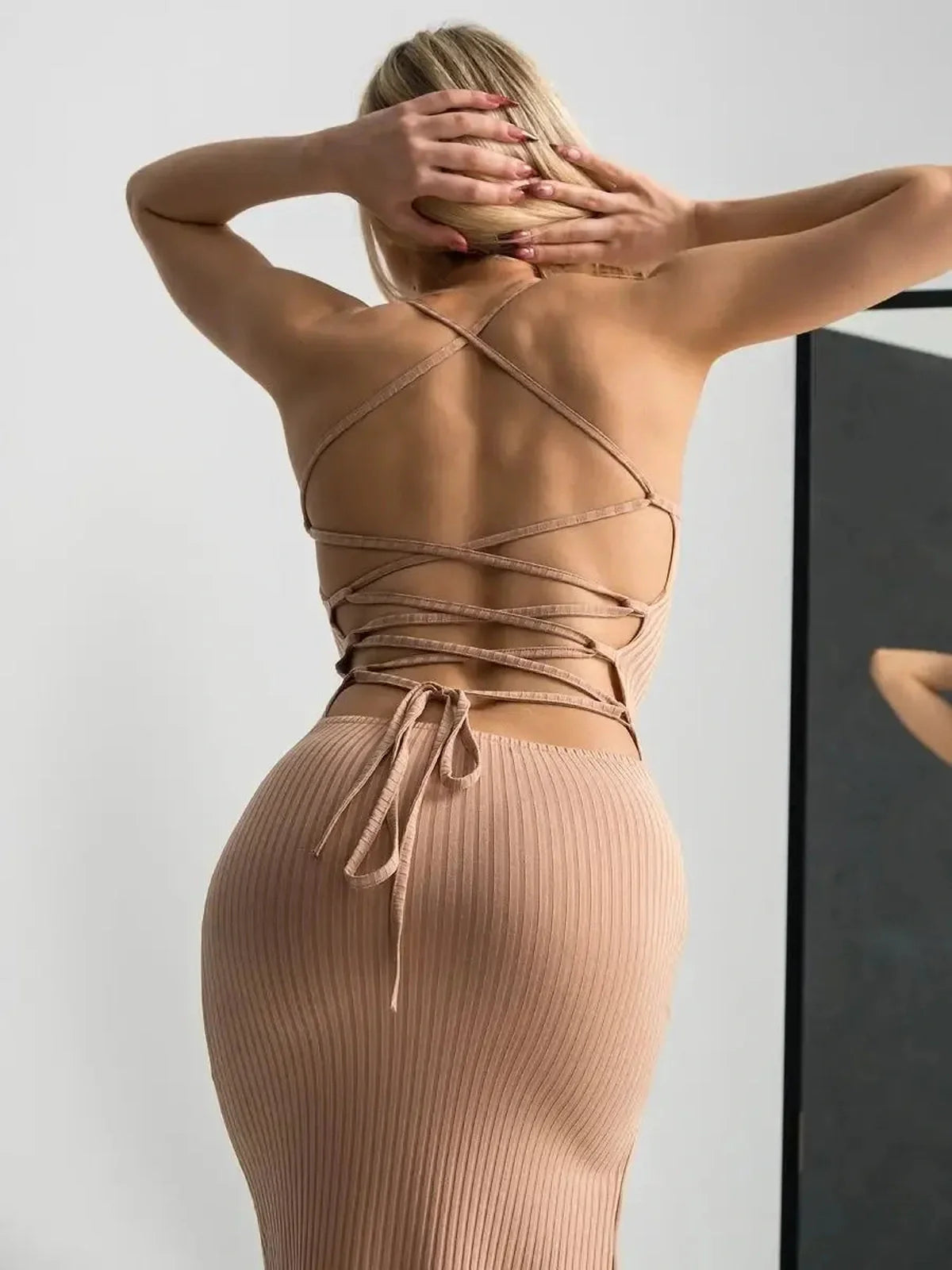 Back view of a Nude Lace Midi Dress showcasing a corset lace-up design and flattering ribbed fit.