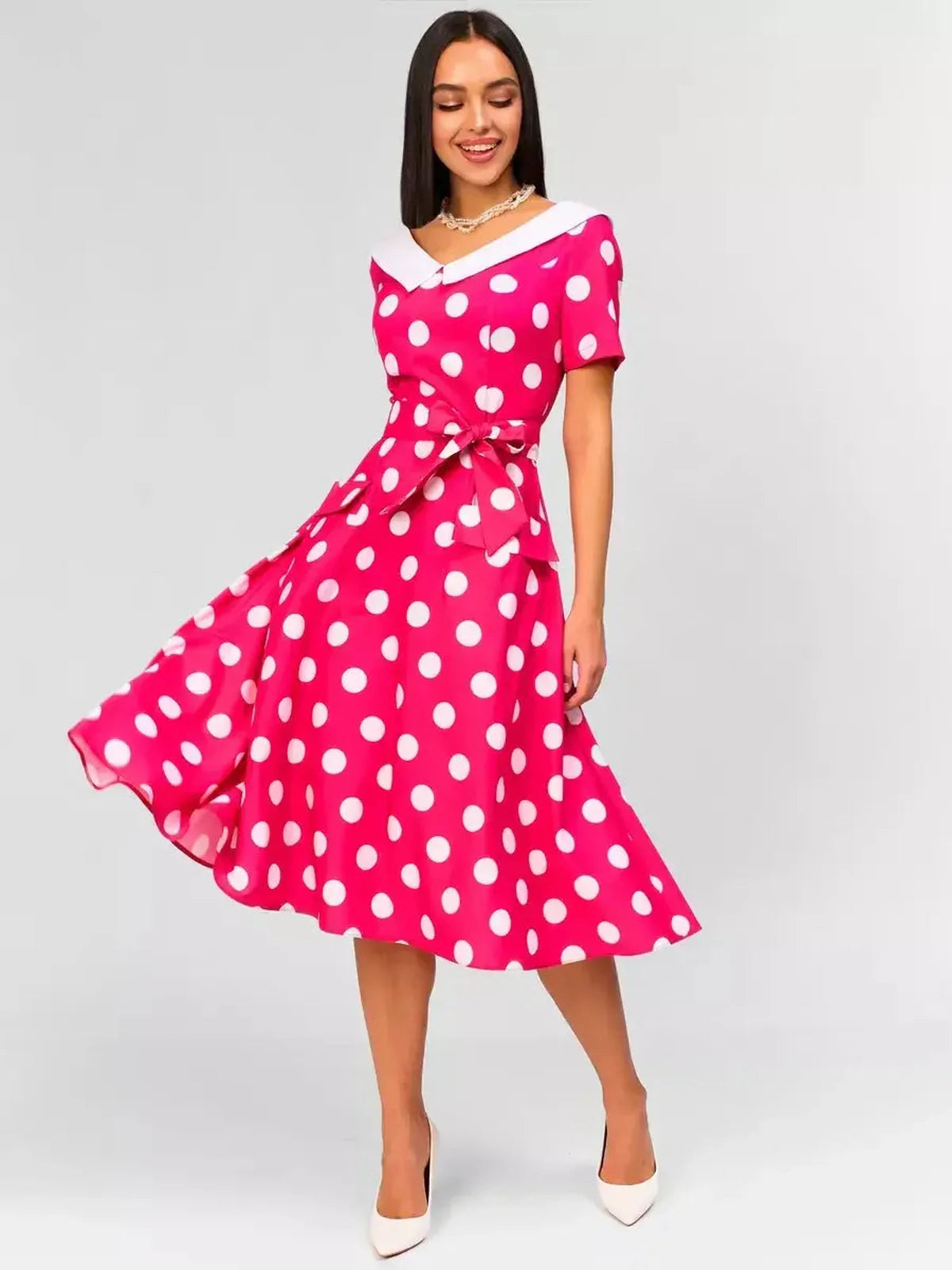 Monaco Charm Midi Dress featuring pink polka dots, white collar, and flattering tie waist, perfect for summer events.