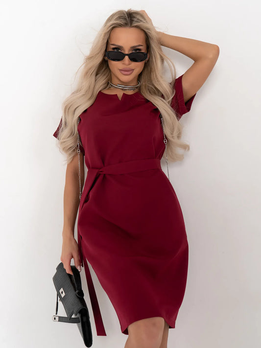 Model wearing the Crimson Code mini dress in wine-red, showcasing a structured design with a detachable belt and stylish accessories.