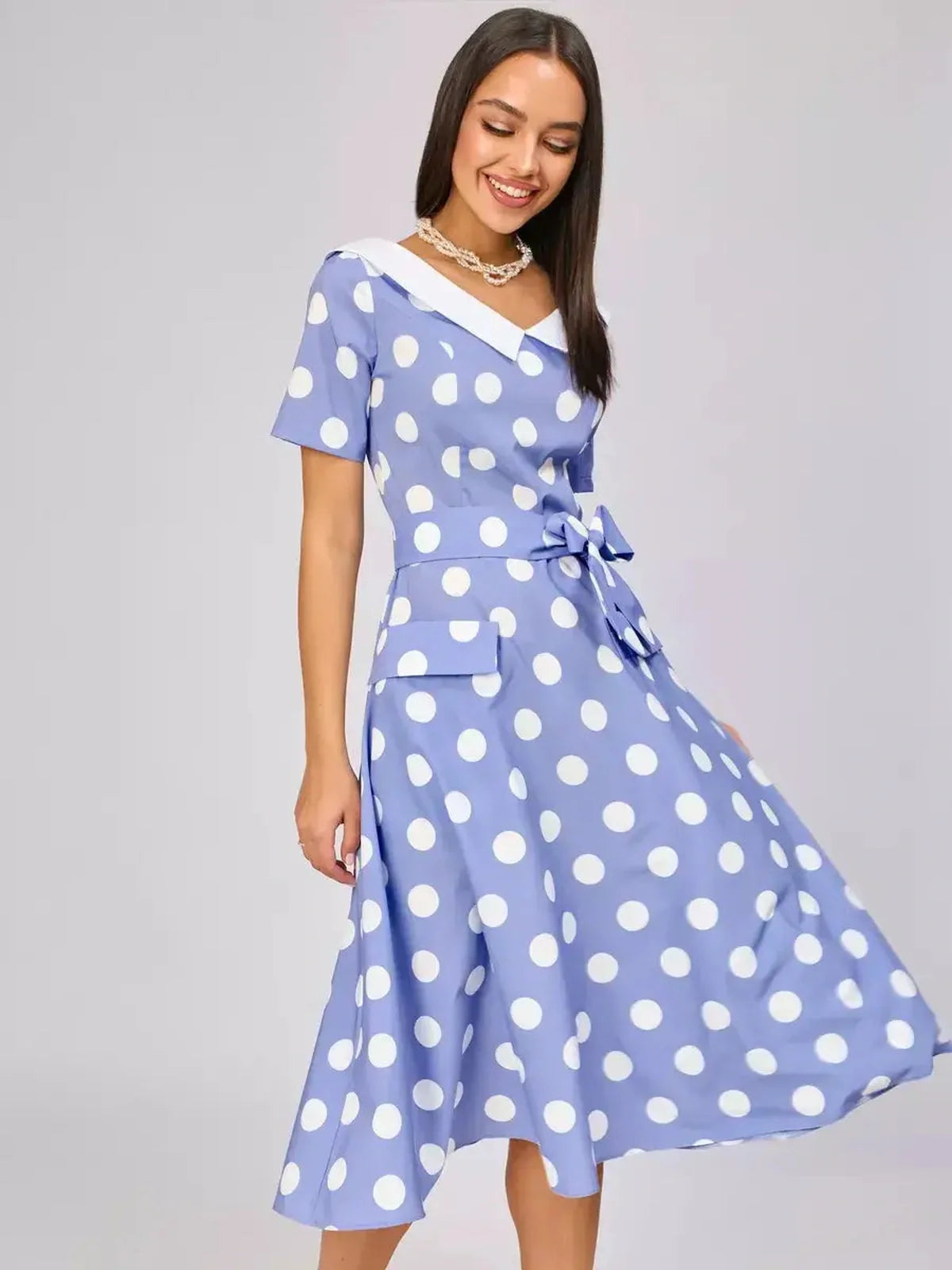 Sky-blue midi dress with white polka dots, flared silhouette, and retro collar, perfect for summer events and weddings.