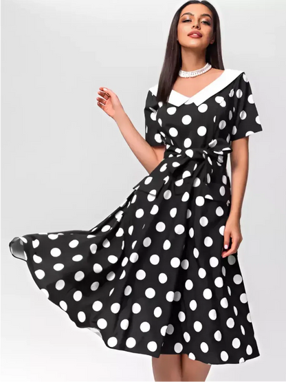 Elegant black and white polka dot midi dress with V-neckline and waist tie, perfect for summer occasions.