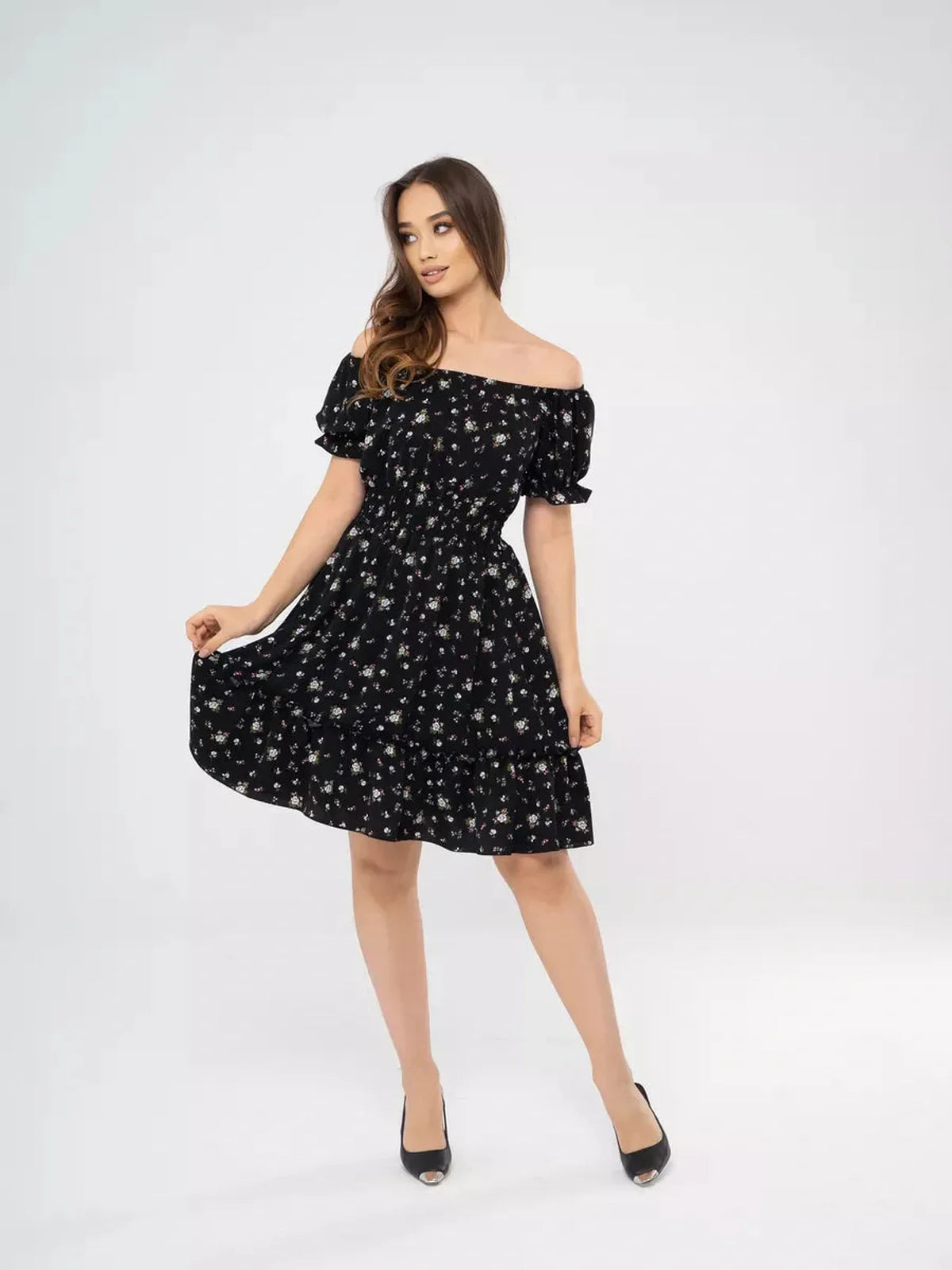 Model showcasing the Midnight Bloom black floral mini dress with off-shoulder neckline and puff sleeves.