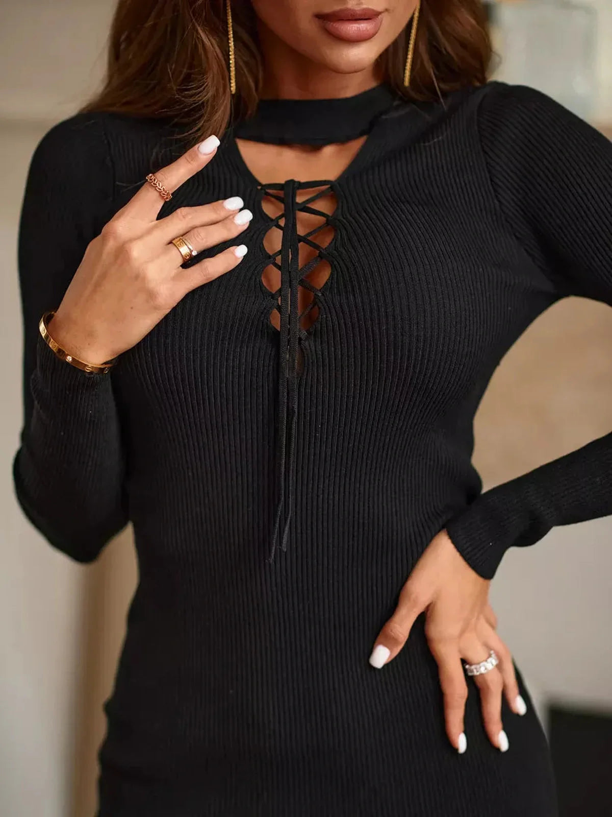 Close-up of a woman wearing a Noir Lace-Up Mini Dress with a ribbed texture and lace-up neckline detail.