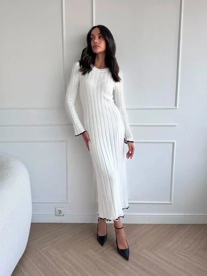 Model showcasing the Ivory Grace Maxi Dress, a chic long white dress with ribbed texture and ruffle trim.
