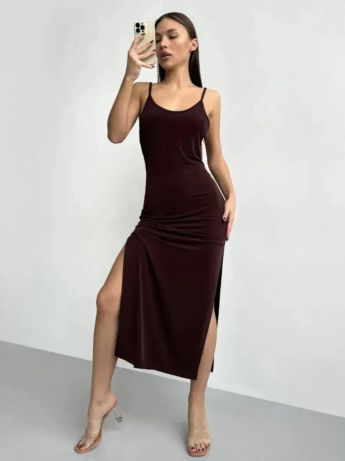 Woman in a sleek burgundy midi dress showcasing a side slit, perfect for evening events and elegant occasions.